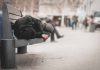 Person sleeping on a bench in a public area