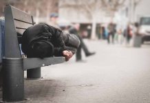 Person sleeping on a bench in a public area