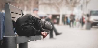 Person sleeping on a bench in a public area