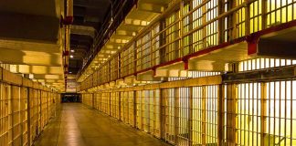 Empty hallway between rows of prison cells
