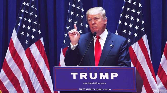 1456399979 featured image Person speaking at podium with multiple American flags.