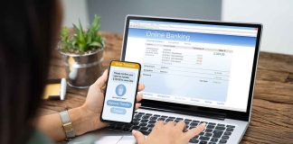 Person using phone and laptop for online banking