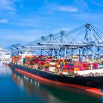 Container ship docked at a busy industrial port