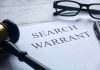 Search warrant document with gavel and glasses
