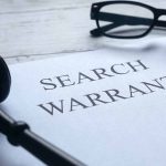 Search warrant document with gavel and glasses