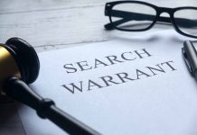 Search warrant document with gavel and glasses