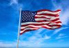 American flag waving against a blue sky