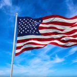 American flag waving against a blue sky