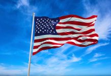 American flag waving against a blue sky