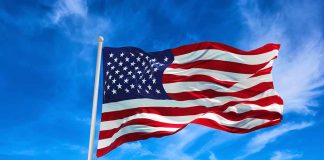 American flag waving against a blue sky