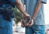 Police officer handcuffing a person on the street