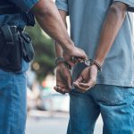 Police officer handcuffing a person on the street