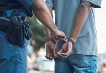 Police officer handcuffing a person on the street