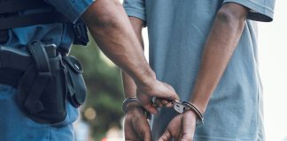 Police officer handcuffing a person on the street