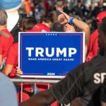Person holding Trump Make America Great Again sign