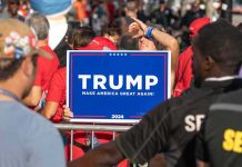 Person holding Trump Make America Great Again sign