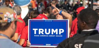 Person holding Trump Make America Great Again sign