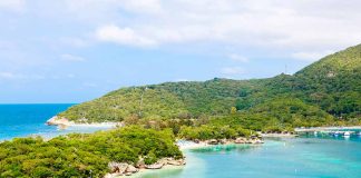 Tropical beach with docks and lush green hills