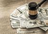 Gavel on a pile of hundred-dollar bills