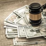 Gavel on a pile of hundred-dollar bills