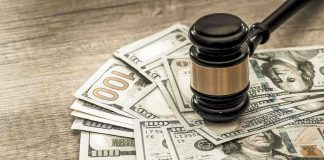 Gavel on a pile of hundred-dollar bills