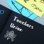 Notebook labeled "Teachers Union" with office supplies.
