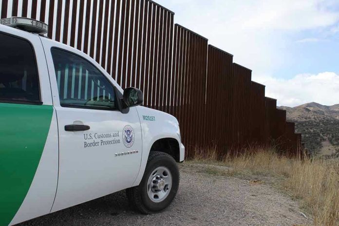 1478048393 Border protection vehicle near a large metal fence