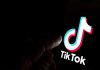 Finger pointing at TikTok logo on a screen