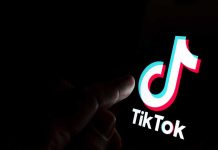 Finger pointing at TikTok logo on a screen