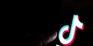 Finger pointing at TikTok logo on a screen