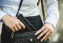 Person placing gun into a handbag