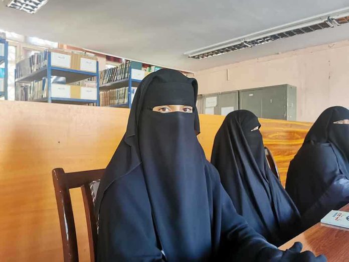 2168982843 featured image Three women in niqabs seated in a library.