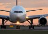 Airplane on runway during sunset.