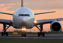 Airplane on runway during sunset.