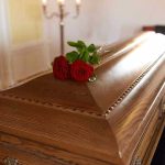 Wooden casket with red roses on top