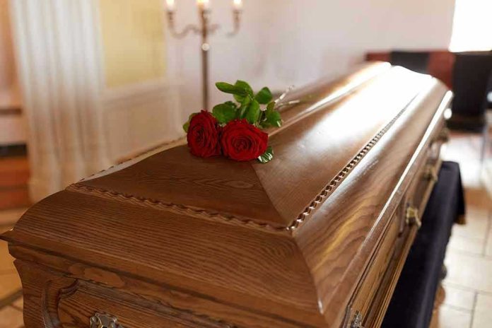 664198003 Wooden casket with red roses on top