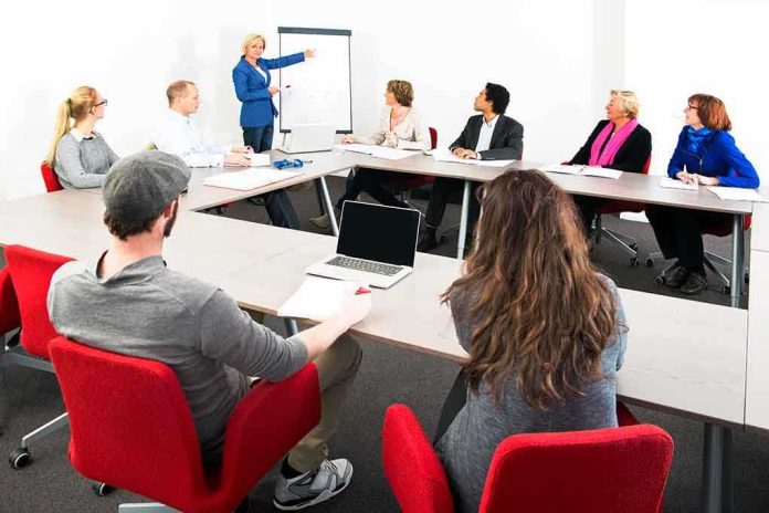 shutterstock_158984081.jpg A diverse group of professionals engaged in a meeting with a presenter at a whiteboard
