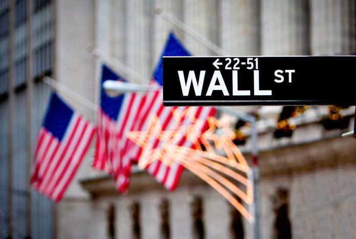 shutterstock_93231562.jpg Wall Street sign with American flags in the background