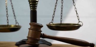 Gavel and scales of justice on wooden table