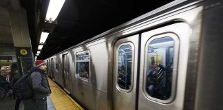 Man waiting at subway platform with departing train