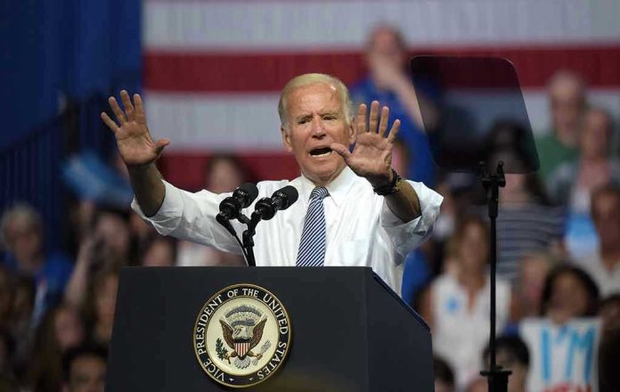 1427778518 A man speaks at podium with raised hands.