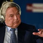 Elderly man speaks with headset and gestures.