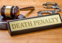 Gavel, handcuffs, and "Death Penalty" sign on desk.
