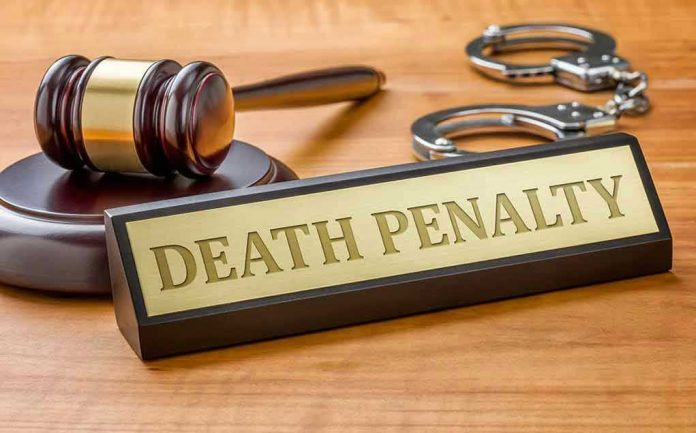 Gavel, handcuffs, and "Death Penalty" sign on desk.