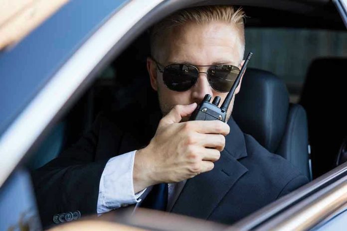 561916870 Man in suit using walkie-talkie in car