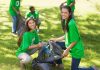 Two young women smiling while participating in a community cleanup event