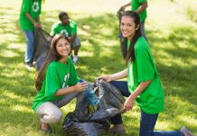 Two young women smiling while participating in a community cleanup event