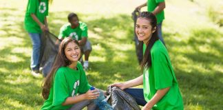 Two young women smiling while participating in a community cleanup event