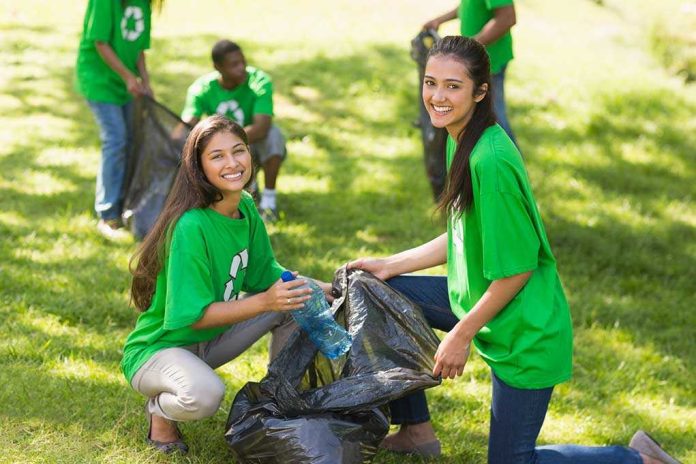 shutterstock_176322620.jpg Two young women smiling while participating in a community cleanup event