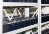 Rows of industrial batteries connected with cables in a storage facility